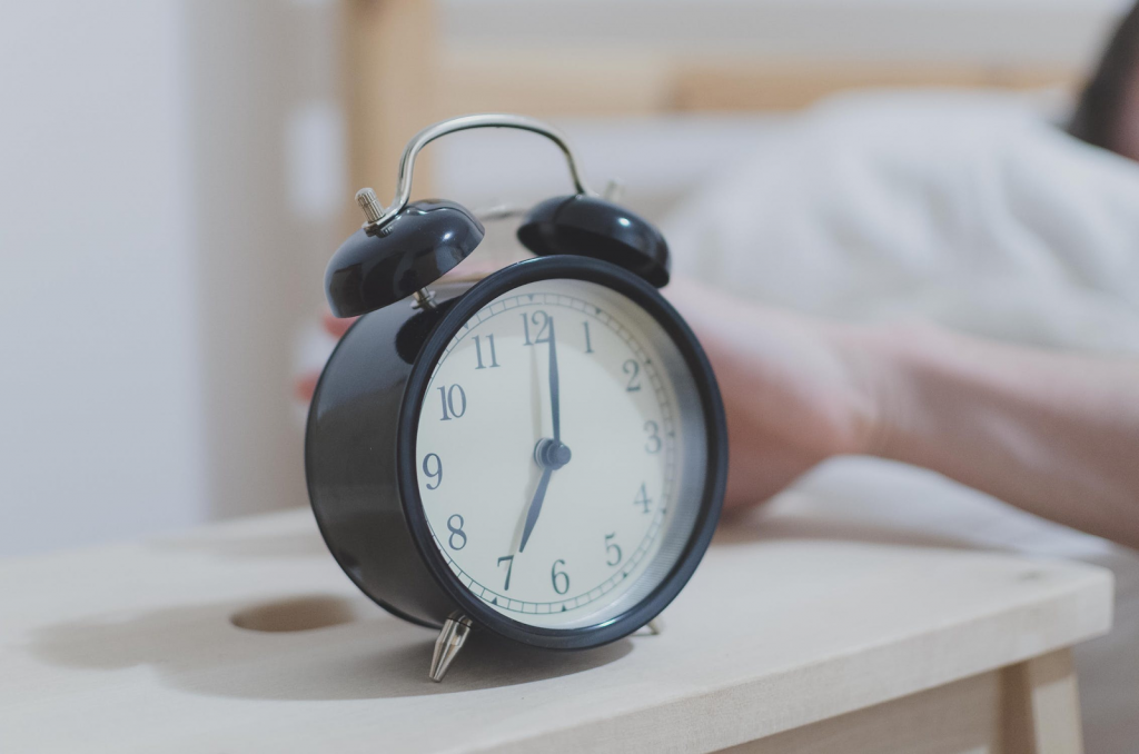 Picture of a hand reaching out to an alarm clock